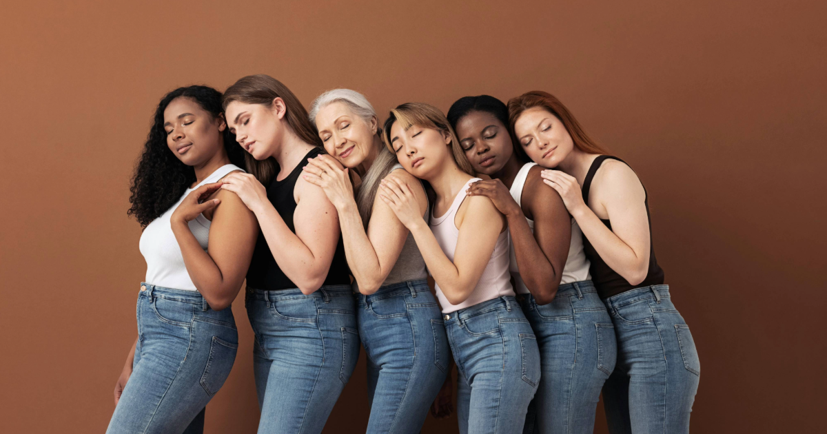 six women standing up lined in a row each leaning on each others back